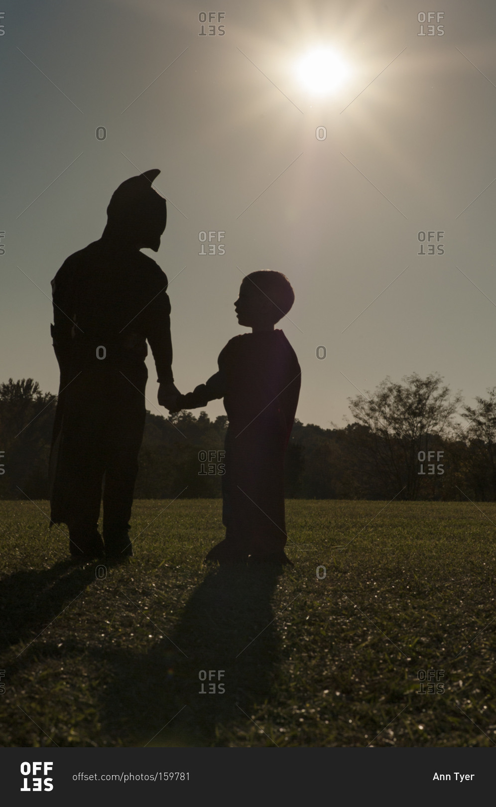 Two boys in costume silhouetted by sun