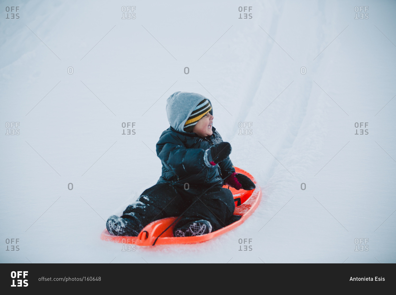 Boy bundled up on sled