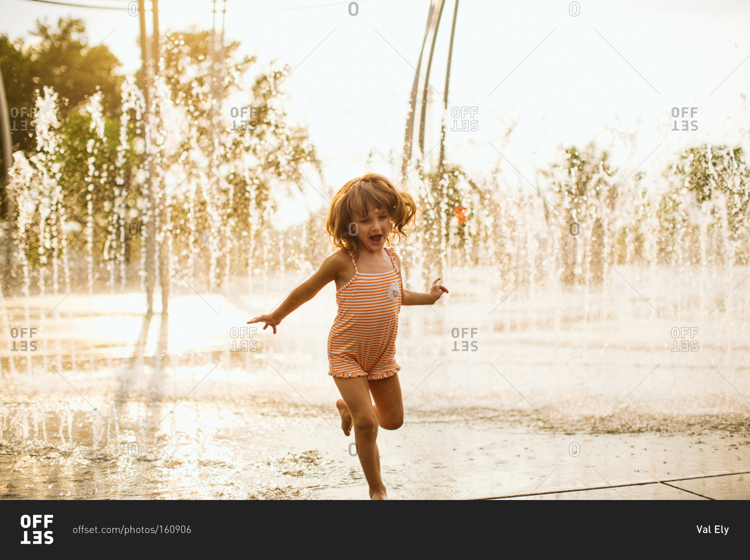 Girl running in fountains in park