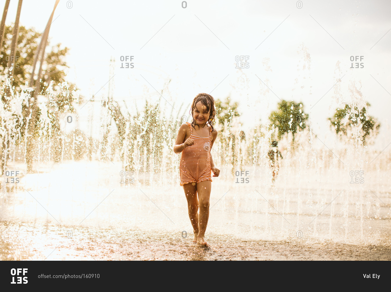 Girl walking through jets in fountain