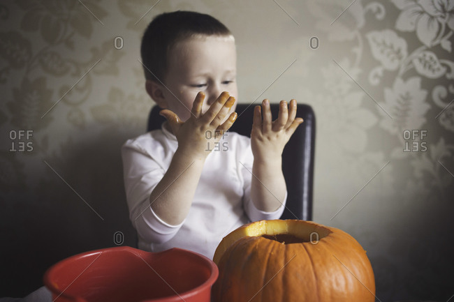 Boy with messy hands and pumpkin
