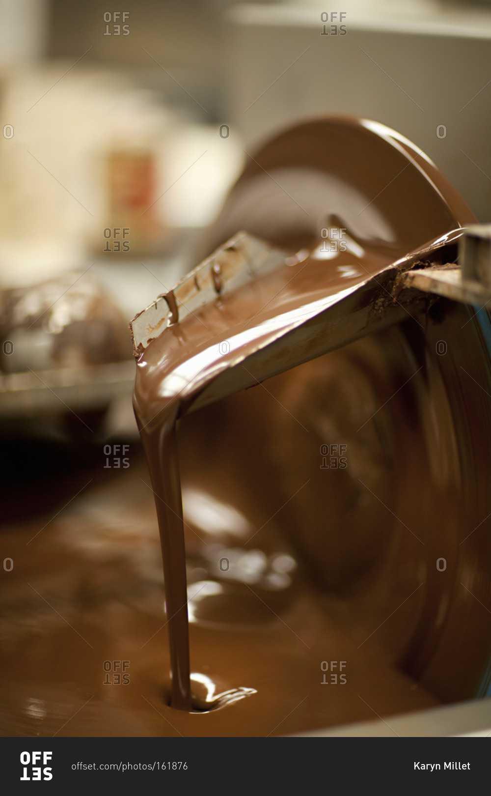 Melted dark chocolate pouring from a machine