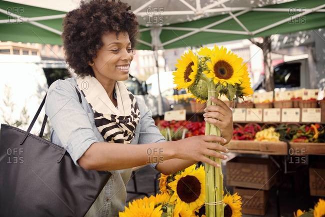 Woman picking out sunflowers in market