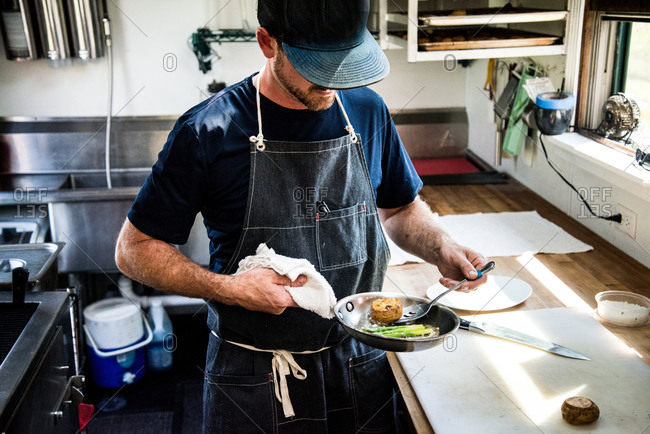 Chef preparing butter-poached lobster with asparagus and new potatoes