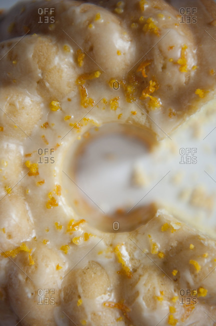 Close up overhead shot of orange cake with citrus glaze with slices removed