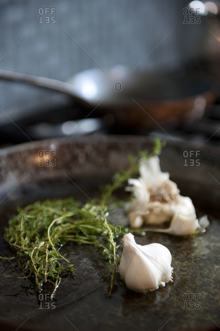 Thyme and whole garlic in a seasoned skillet