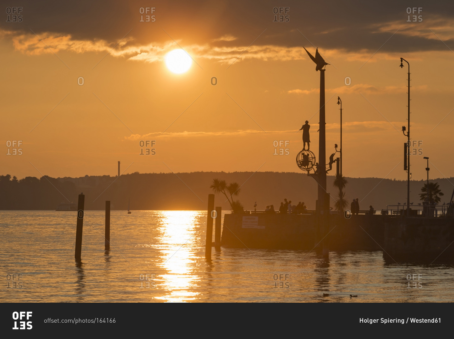 Harbor entrance with sculpture magical pillar at sunset, Lake Constance