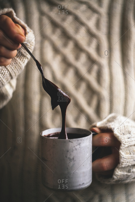 Woman holding mug of melted chocolate