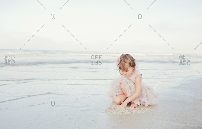 Little girl playing in the sand on beach