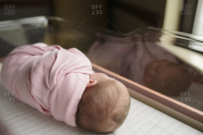 Newborn baby girl napping in a crib