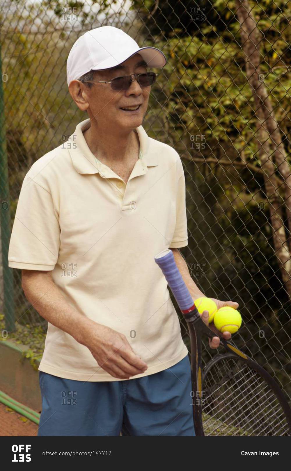 Portrait of senior man with tennis racket