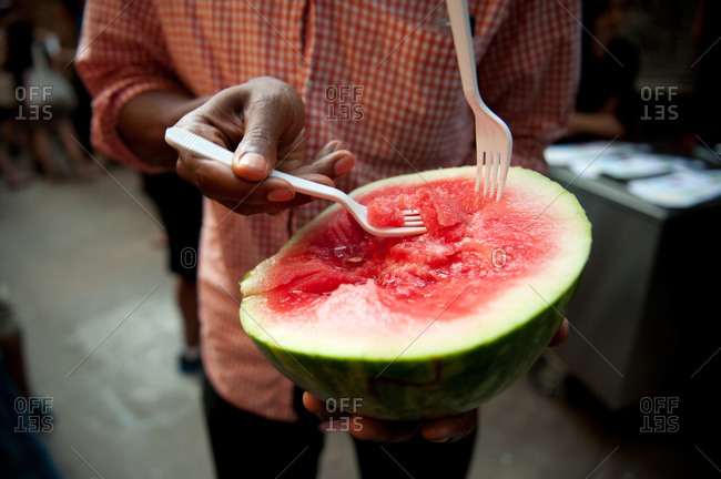 Eating half a small watermelon with forks