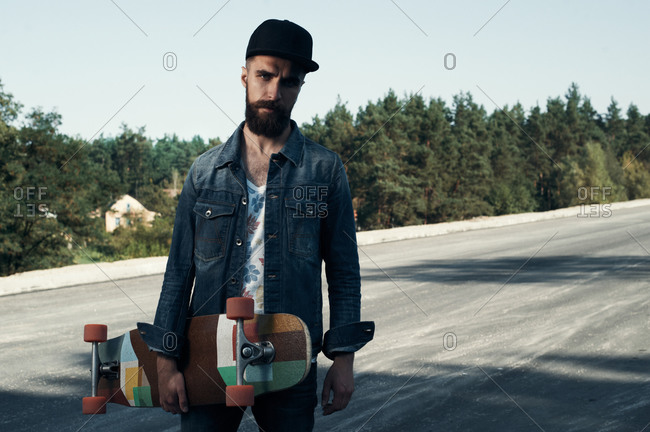 Bearded man holding skateboard