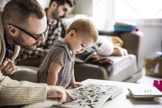 Father showing a picture book to his daughter
