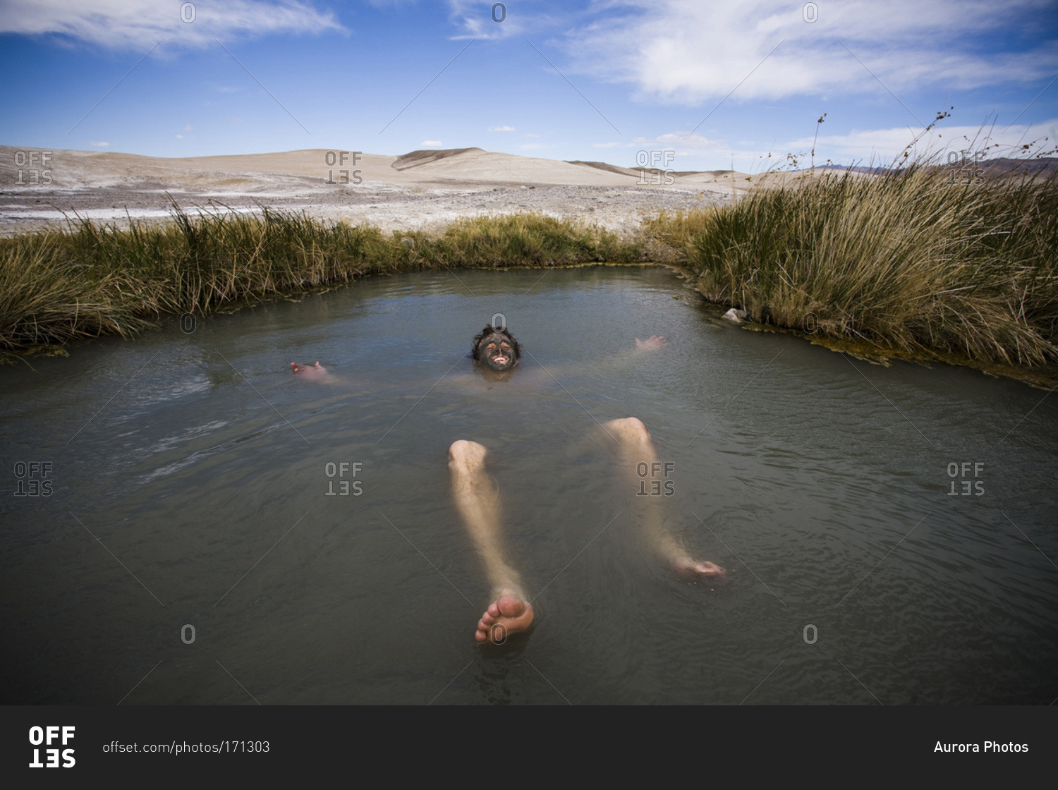 A man floats on his back in roadside hot springs in Tecopa