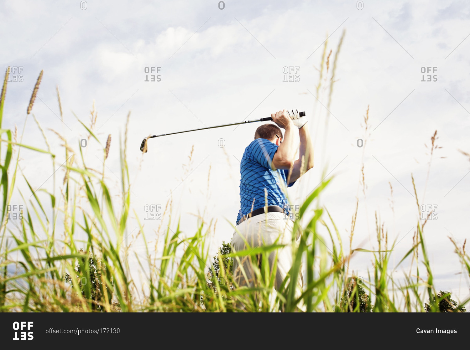 Low angle view of man playing golf stock photo OFFSET