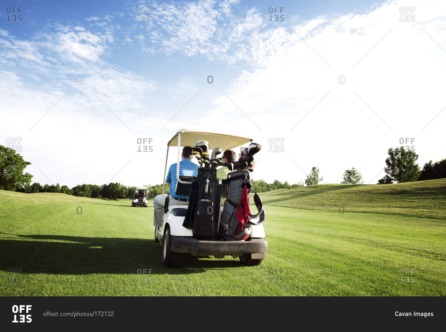 Men riding in a golf cart in a golf course