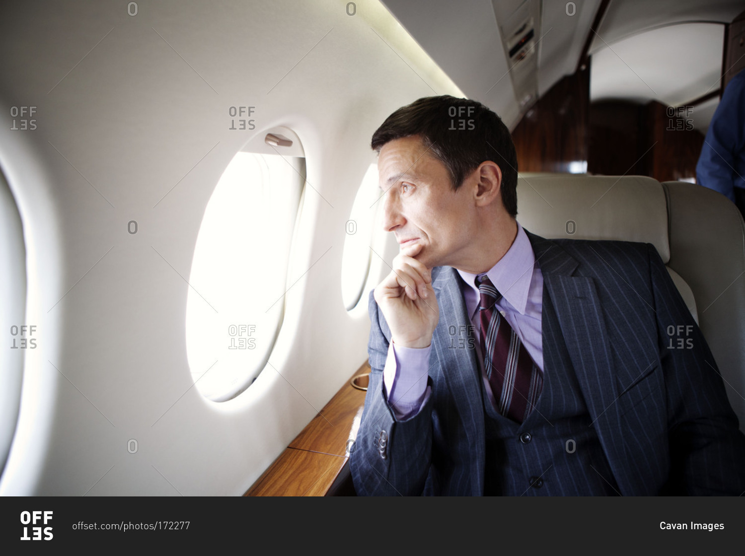 Businessman staring out of window of a private jet