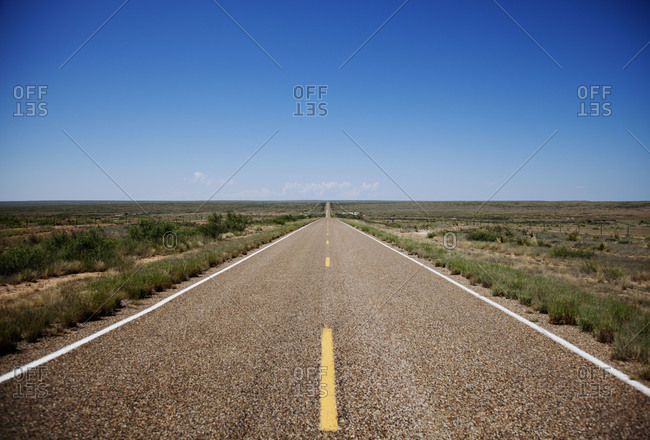 Empty road crossing a plain