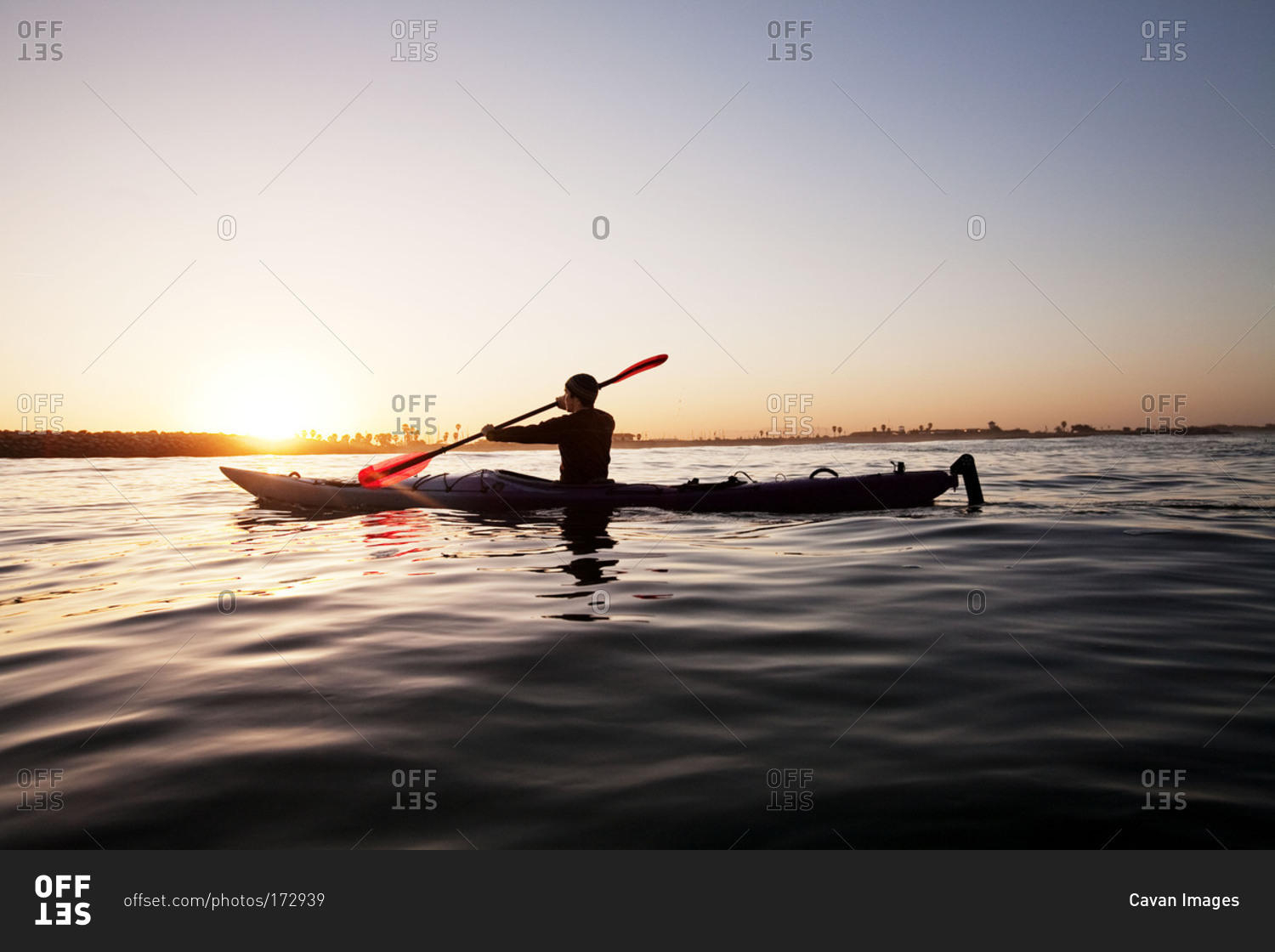 A man paddling a kayak by himself