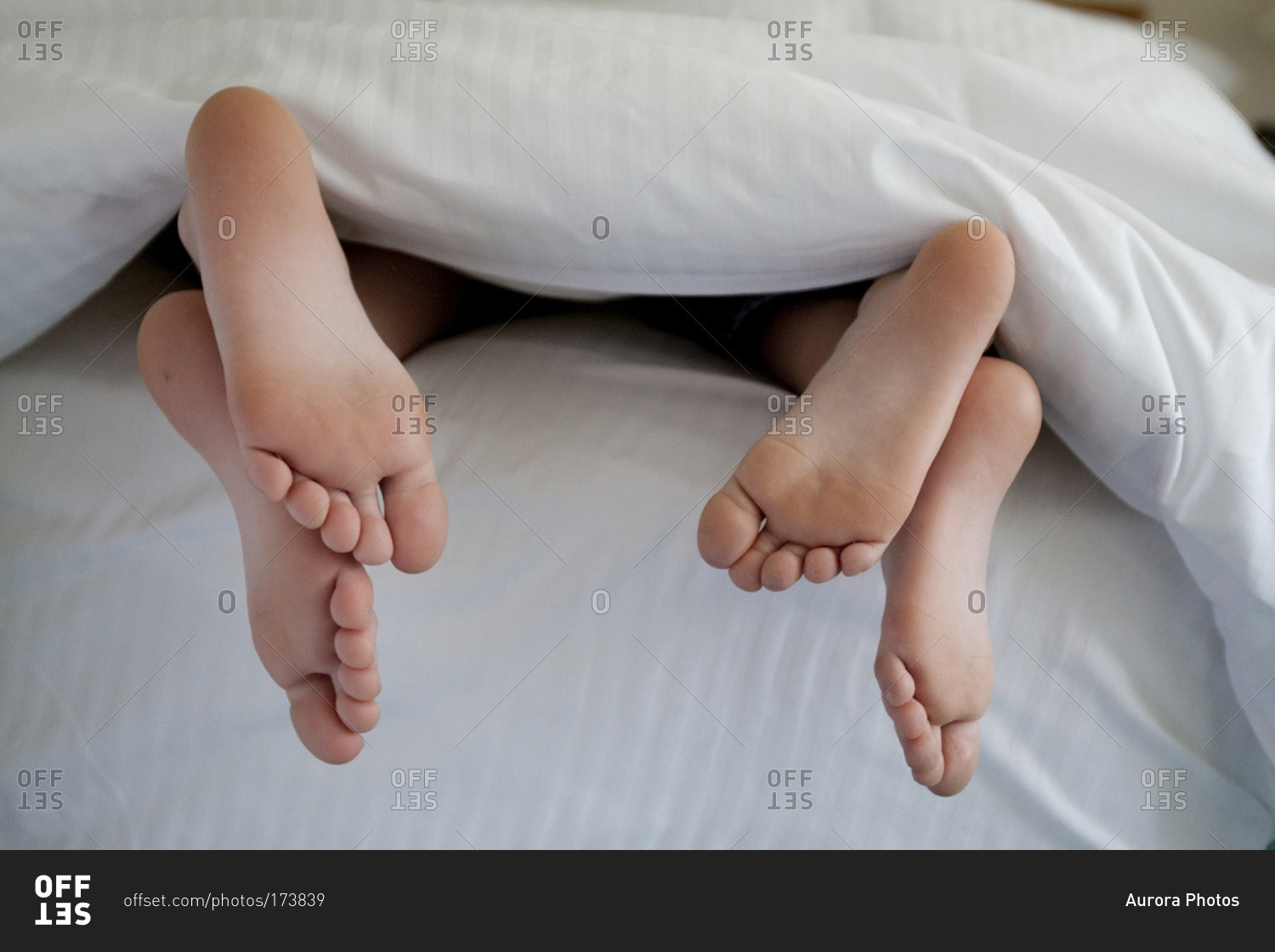 Feet Sticking Out Of Bed Covers Stock Photo OFFSET