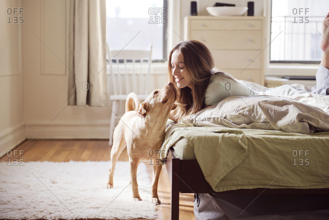A woman cuddles with her dog in the morning