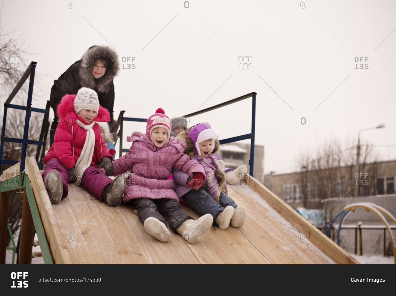 Little girls going down slide in winter