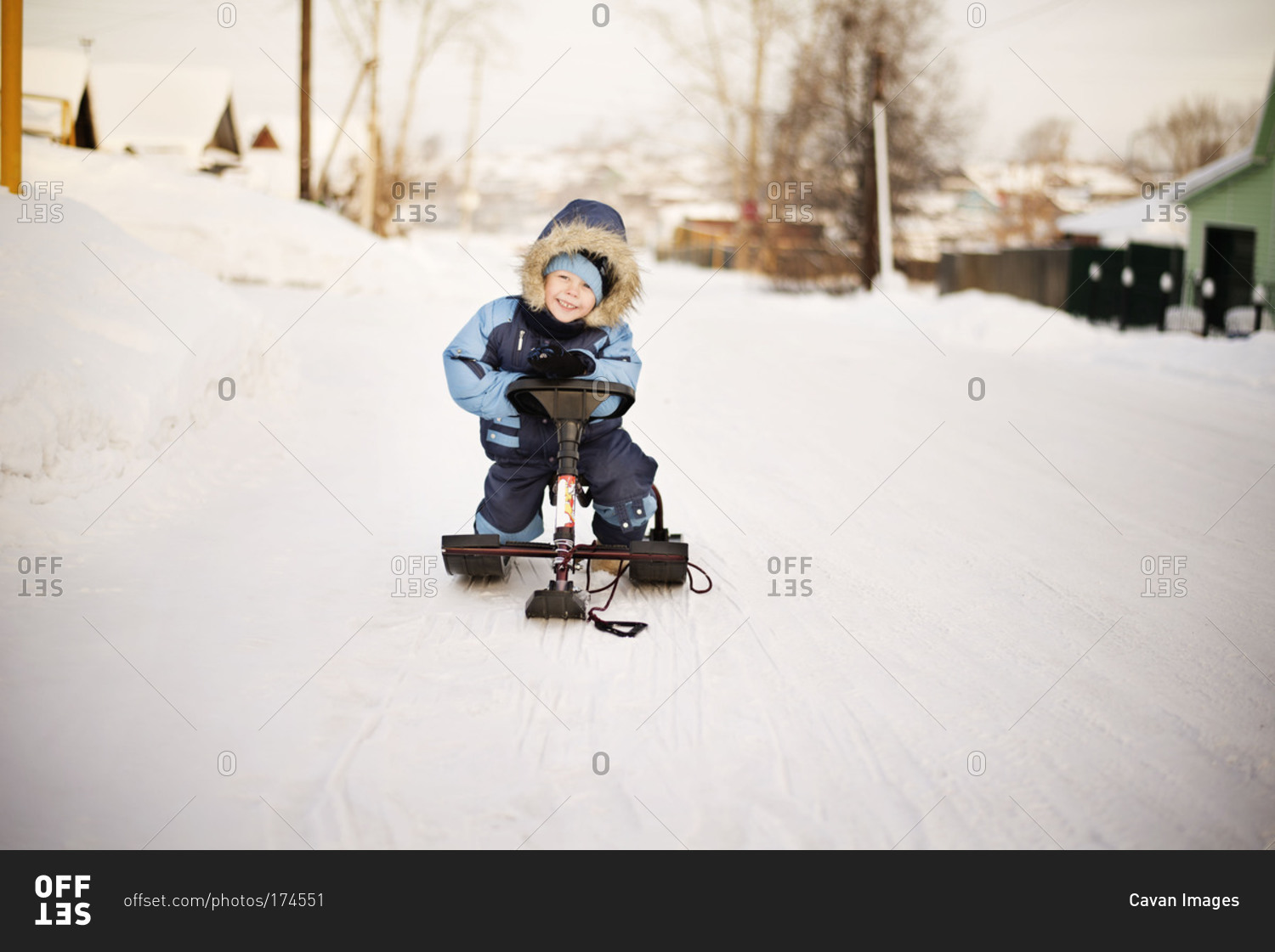 Little boy on mini snowmobile