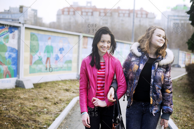 Two Girls Walking With Arms Linked Stock Photo Offset