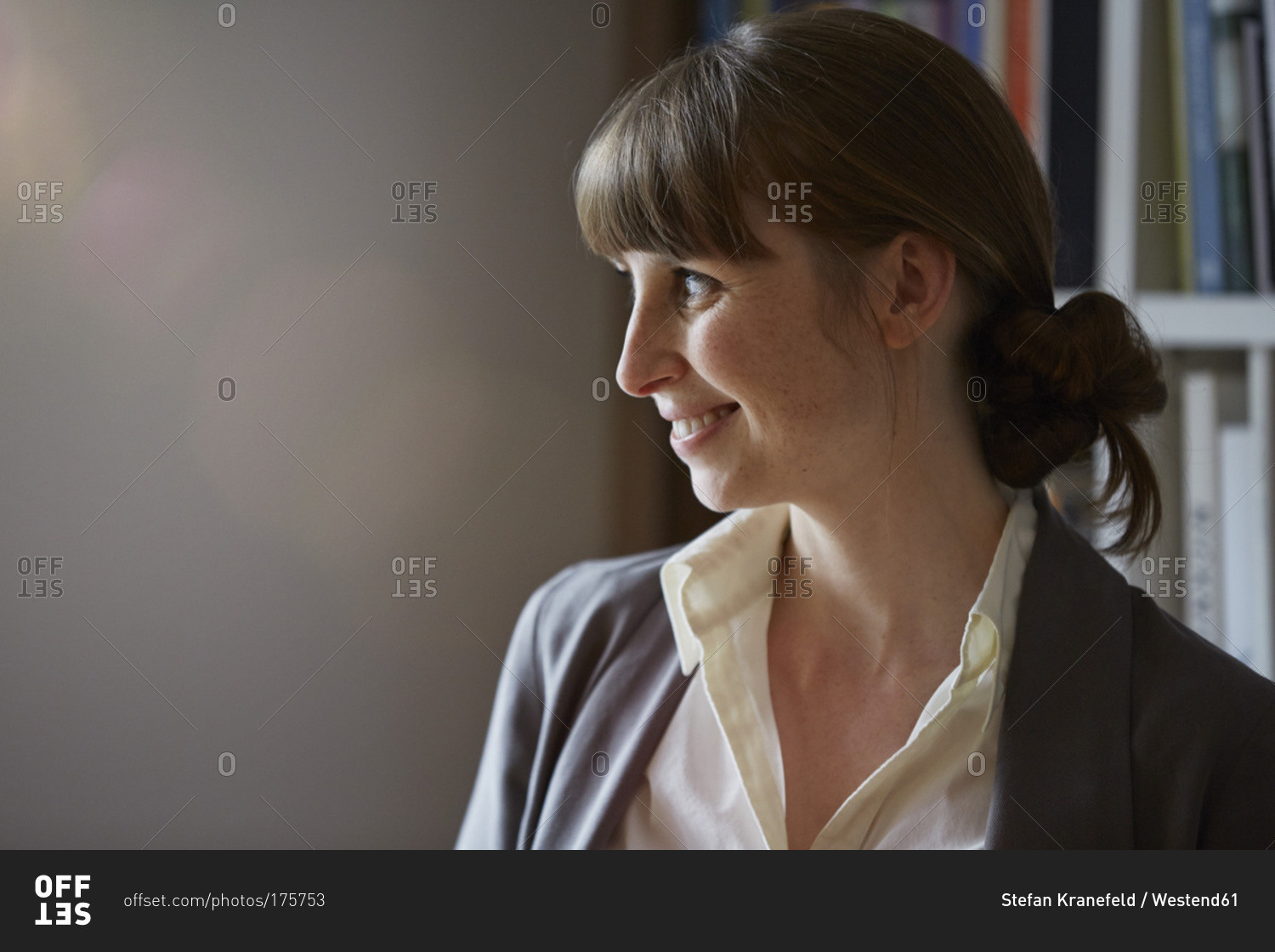Smiling woman in front of book shelf