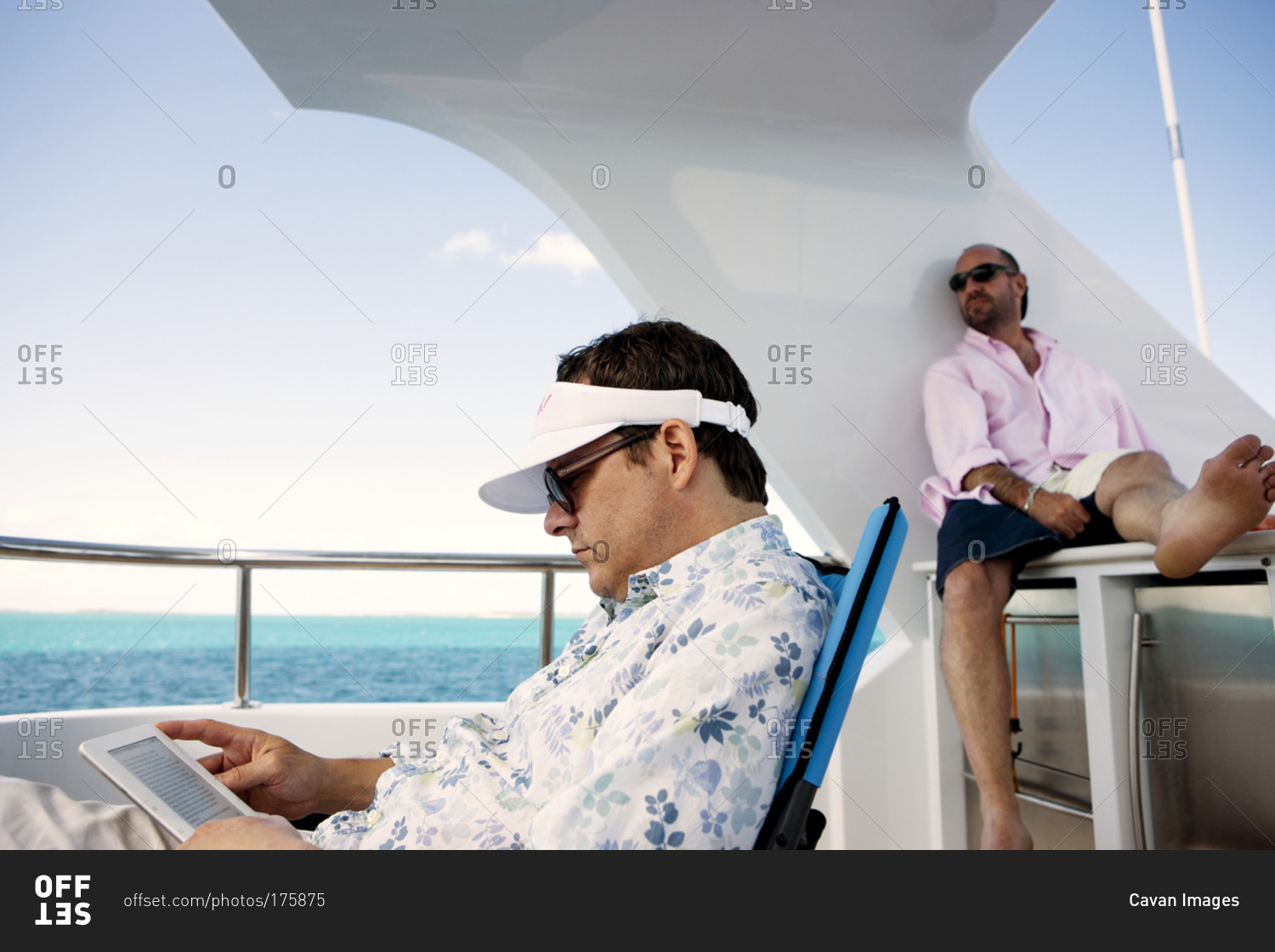 Two men lounge on the deck of a yacht