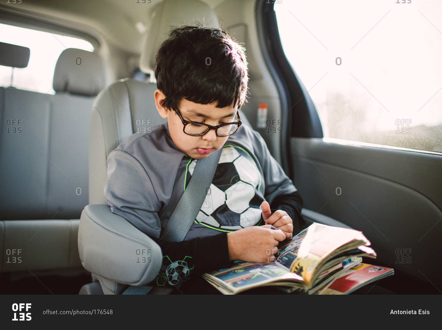 Boy reading comic books in car