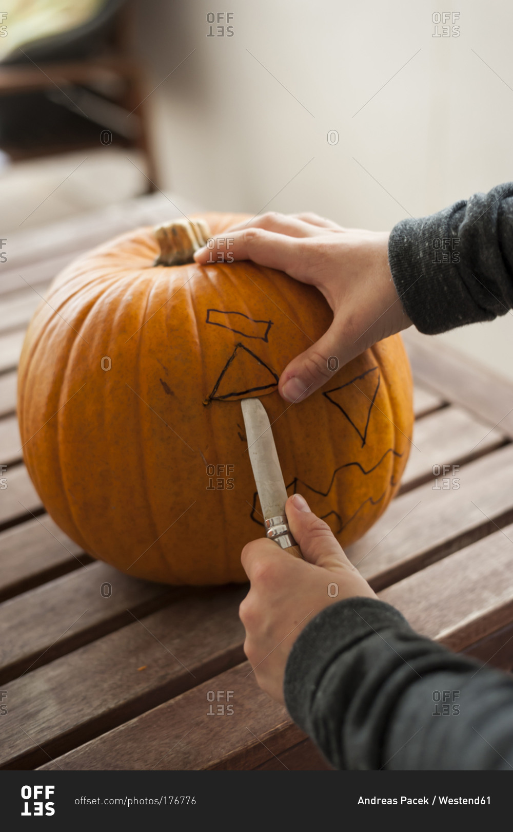 Boy's hands preparing a pumpkin for Halloween lantern