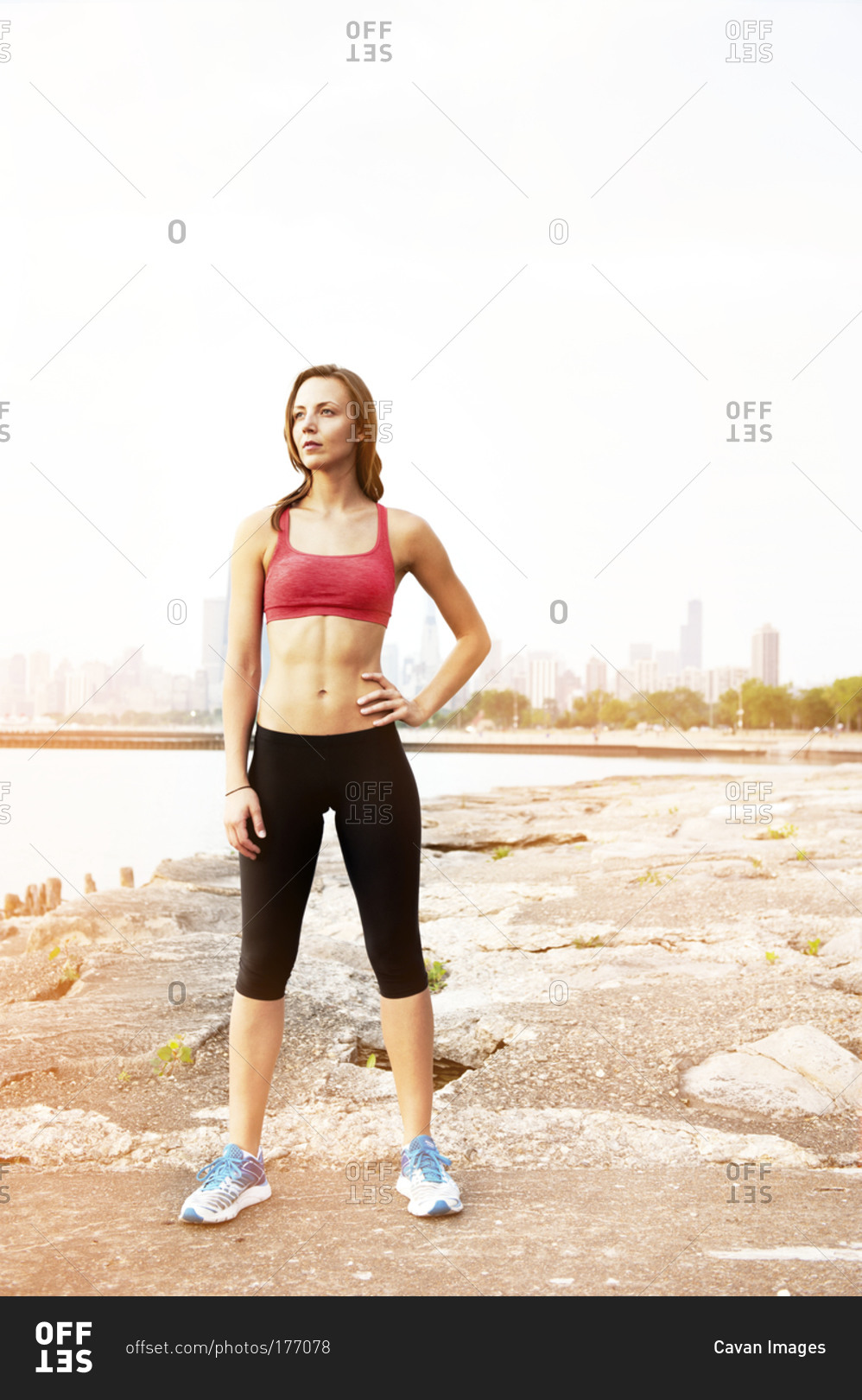 A woman in workout gear stands in front of the Chicago skyline