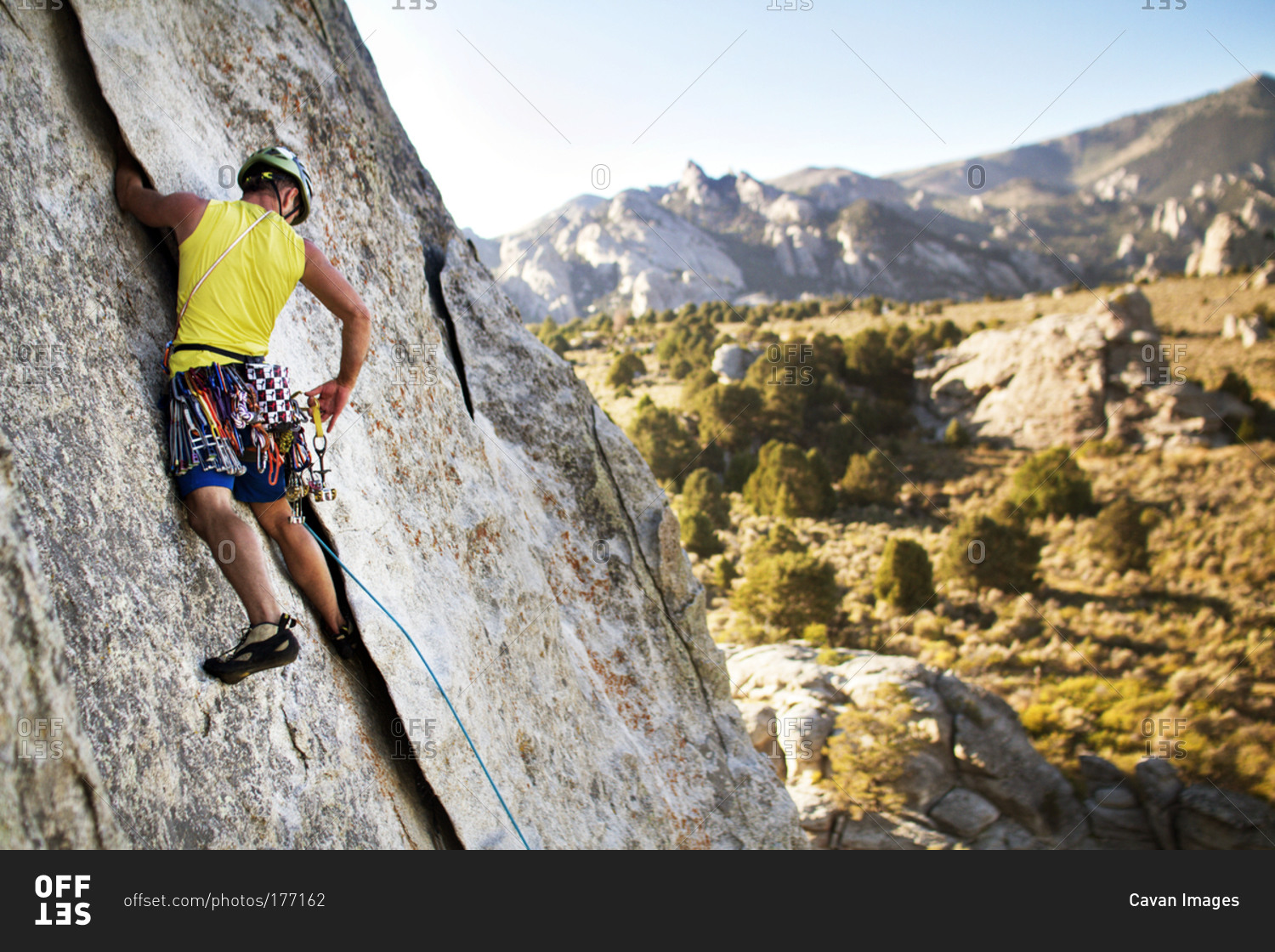A rock climber reaches for an anchor