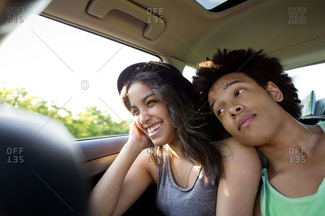 Two friends cuddling in backseat of a car