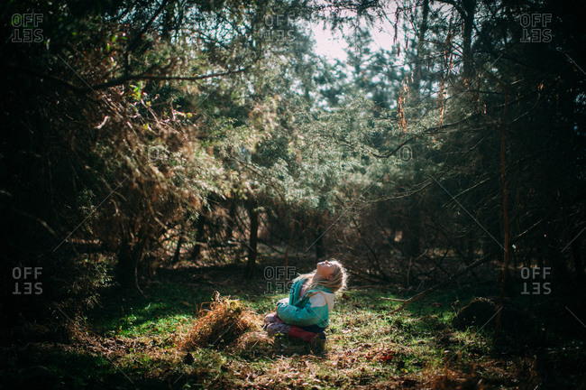 Girl enjoying warmth of the sun in woods