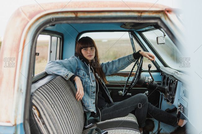 Passenger door view of woman driving a pickup truck stock photo - OFFSET