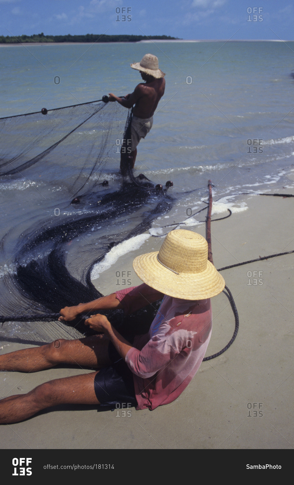 Fishermen casting net in sea