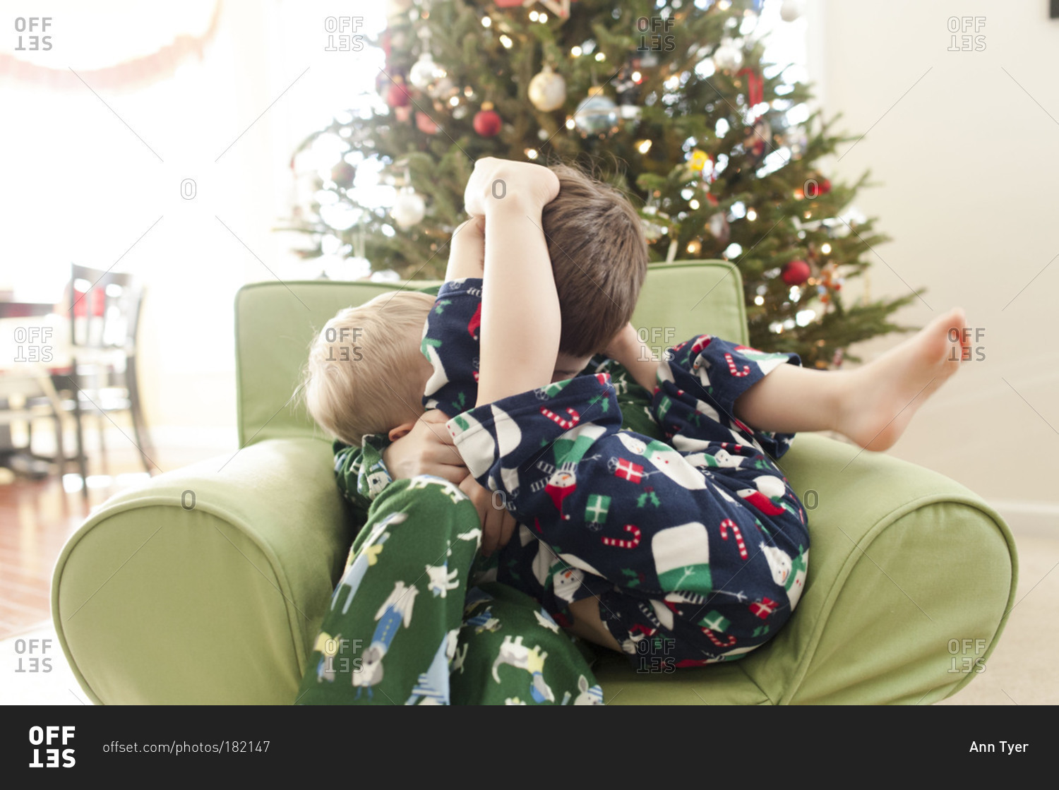 Brothers wrestling in an armchair
