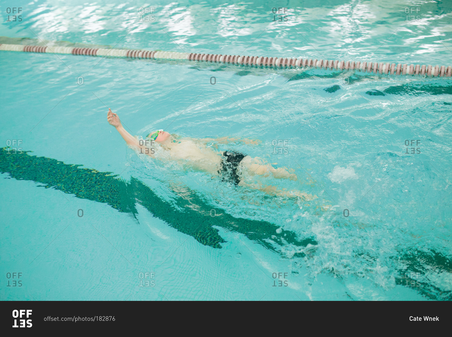 Boy swimming backstroke in pool