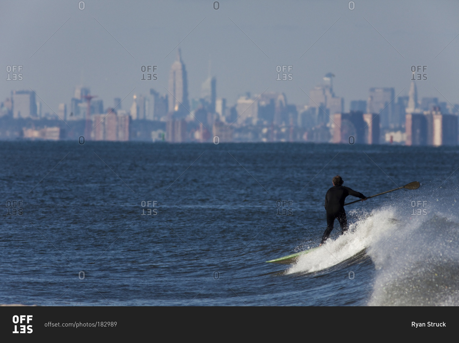 Paddle boarder surfing in waters off Manhattan