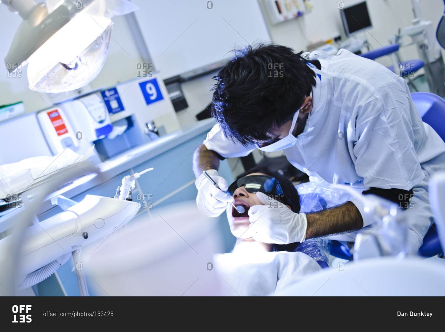 A dental student performing dental surgery on a patient