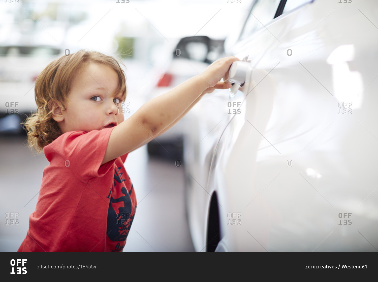 Boy at car dealer examining car