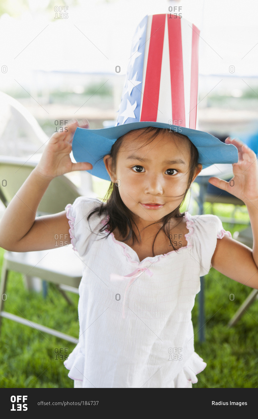 Portrait of young girl outdoors wearing a patriotic paper hat