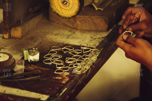 A metalsmith checks hooks made at an Indonesian garment factory