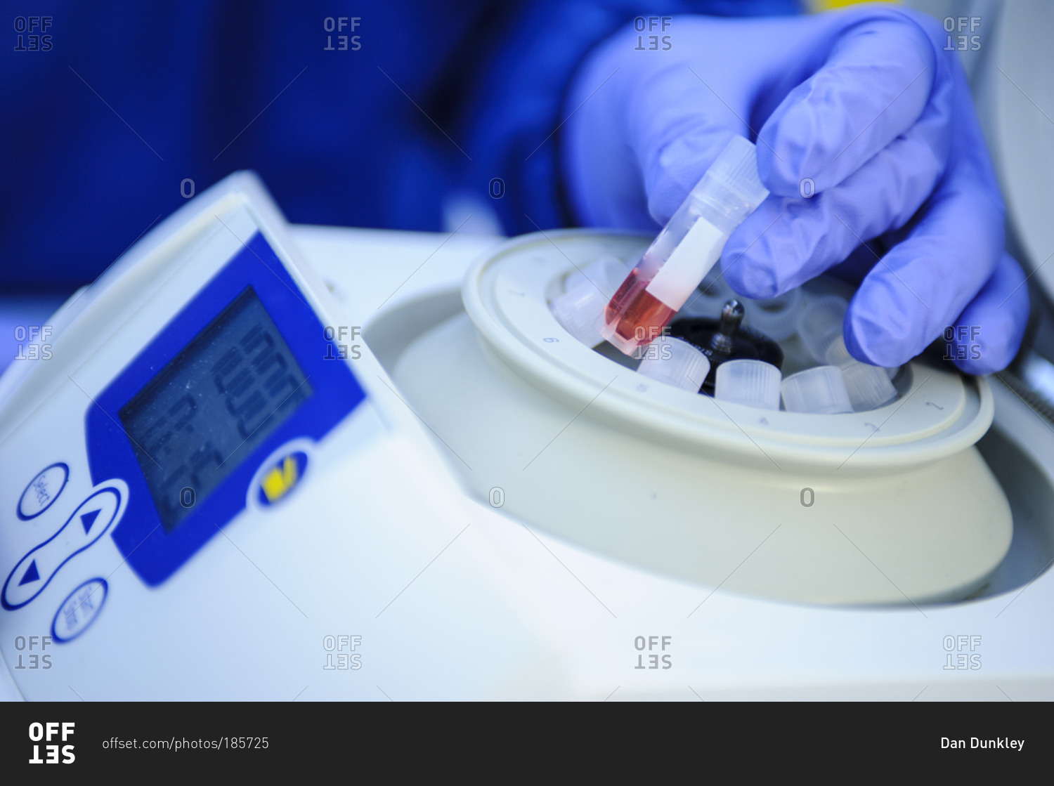 Close up of technician loading samples into a centrifuge in a laboratory