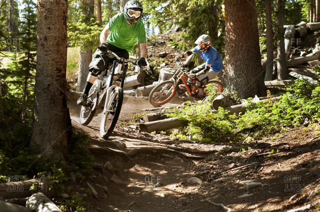 Bikers racing down a track in the woods