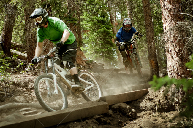 People racing down an obstacle course in a bike park