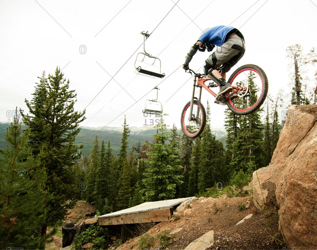 Downhill biker jumping down on a trail